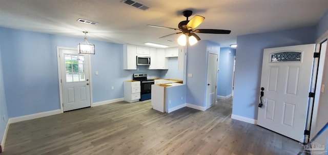 kitchen featuring white cabinetry, stainless steel appliances, wood counters, pendant lighting, and light wood-type flooring