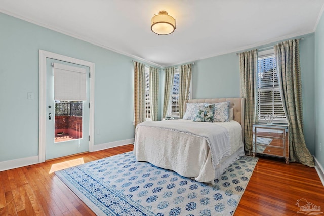 bedroom with crown molding, baseboards, and wood finished floors