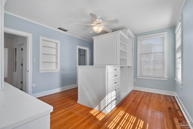 spacious closet with light wood-type flooring, visible vents, and ceiling fan