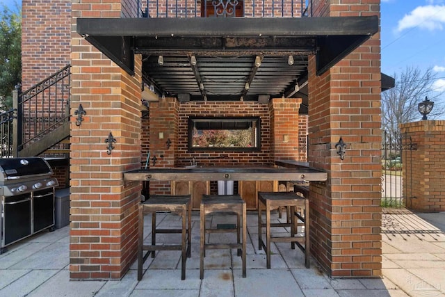 view of patio featuring an outdoor kitchen, area for grilling, and outdoor wet bar