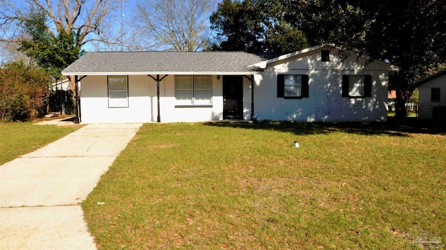 ranch-style house with concrete block siding and a front yard