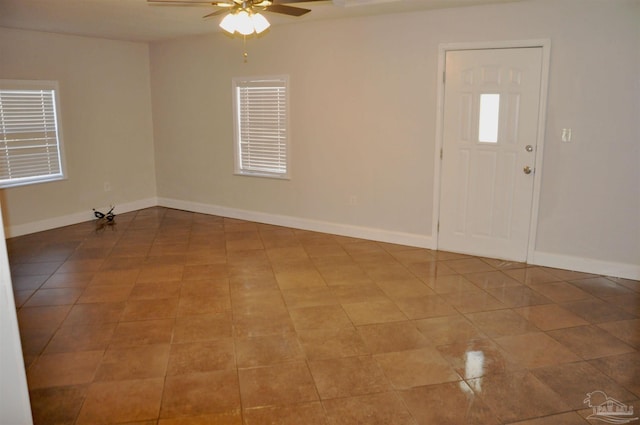 interior space featuring baseboards and a ceiling fan