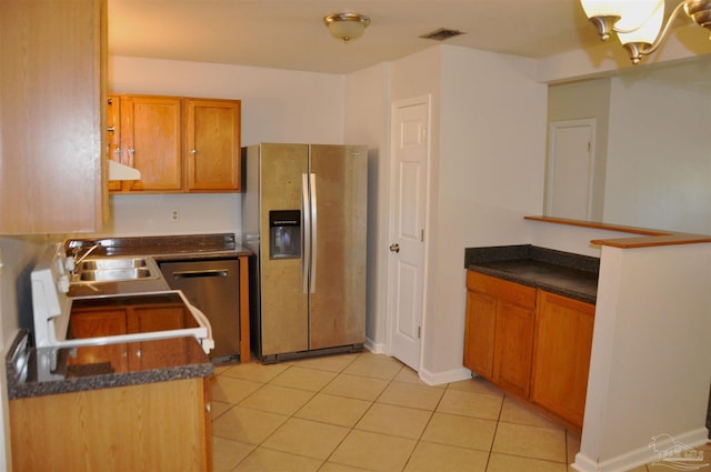 kitchen featuring light tile patterned floors, visible vents, dark countertops, and appliances with stainless steel finishes