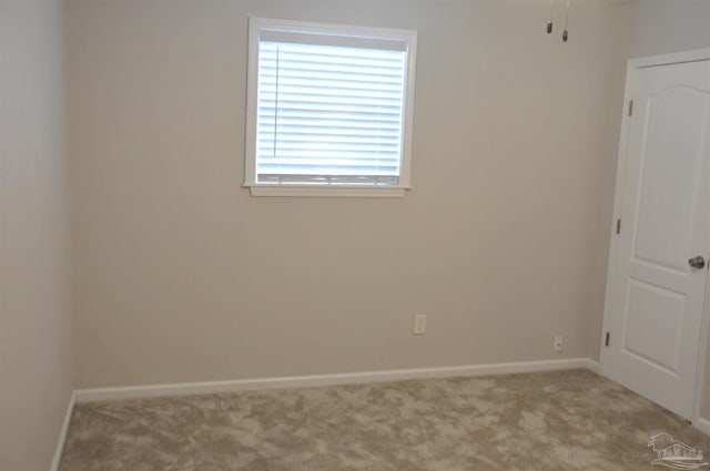 carpeted spare room featuring baseboards