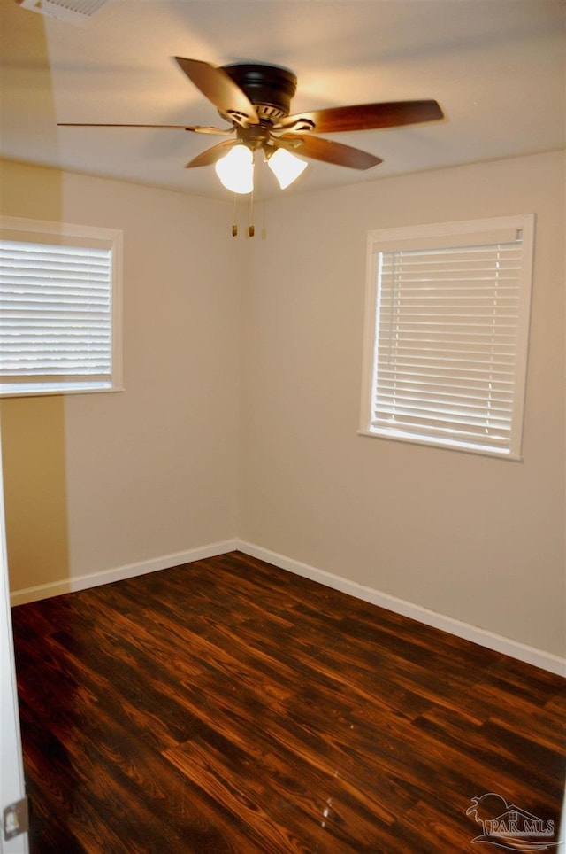 spare room featuring ceiling fan, baseboards, and dark wood-style floors