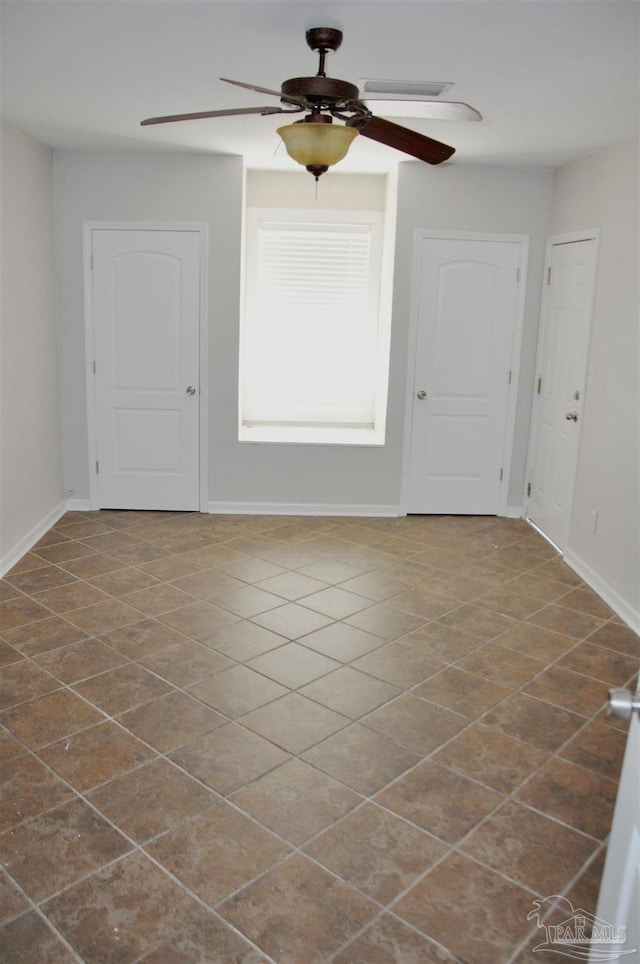 empty room with baseboards and ceiling fan