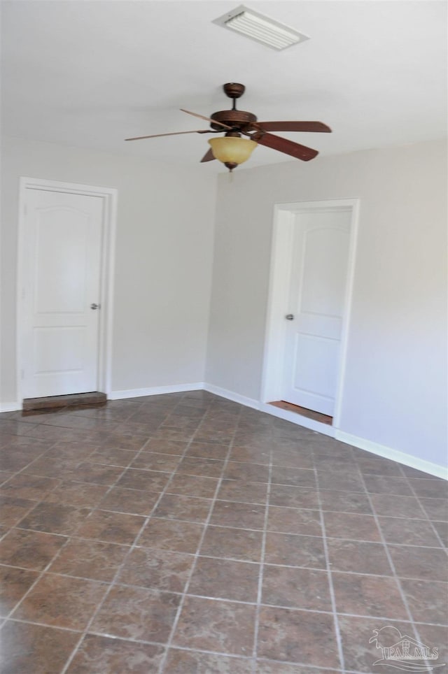 spare room with a ceiling fan, baseboards, and visible vents