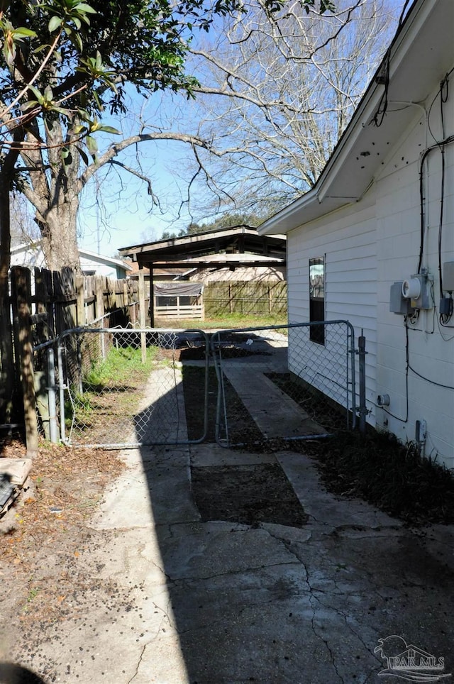 view of side of property with a carport and fence