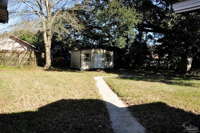 view of yard featuring an outdoor structure, a storage unit, and fence