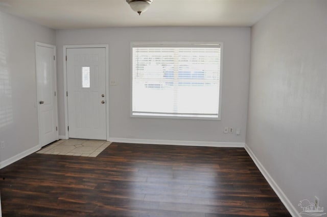 foyer entrance featuring baseboards and wood finished floors