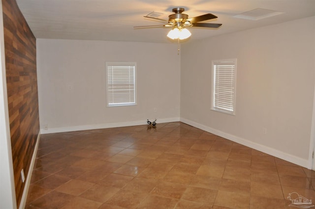 spare room with a ceiling fan and baseboards