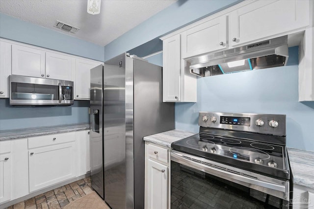 kitchen featuring white cabinetry, stainless steel appliances, and a textured ceiling