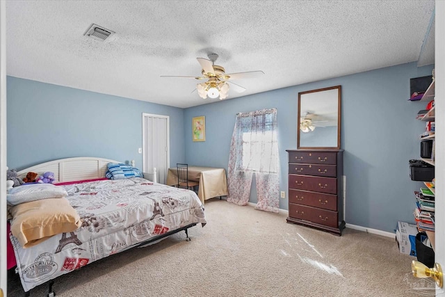 bedroom with a textured ceiling, ceiling fan, and carpet flooring