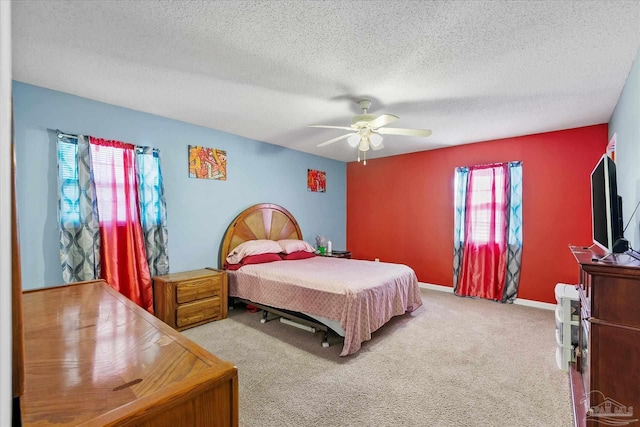 carpeted bedroom with ceiling fan, multiple windows, and a textured ceiling