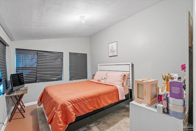 bedroom with vaulted ceiling and a textured ceiling