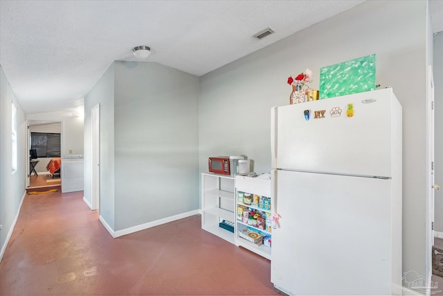 kitchen with white fridge and a textured ceiling