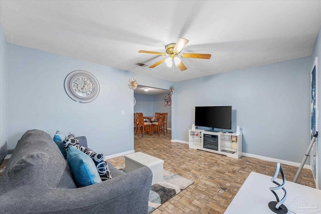 living room with a textured ceiling and ceiling fan