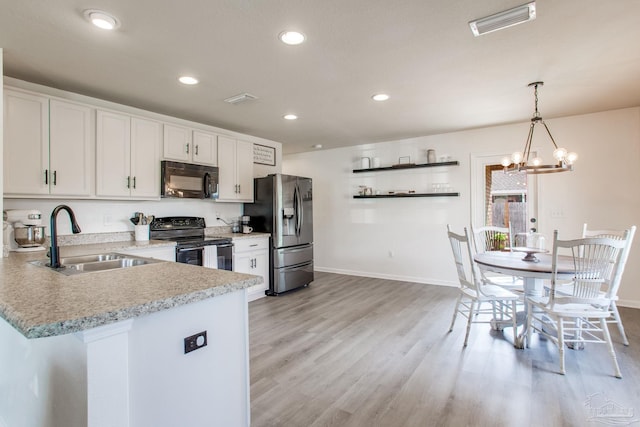 kitchen featuring baseboards, a sink, black appliances, and light countertops