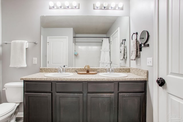 bathroom featuring a sink, curtained shower, toilet, and double vanity