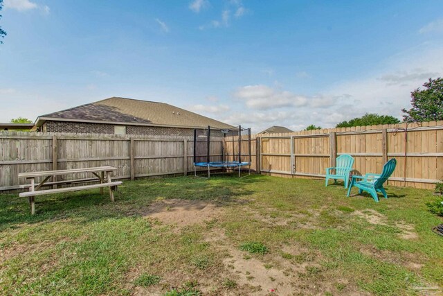 view of yard featuring a fenced backyard and a trampoline