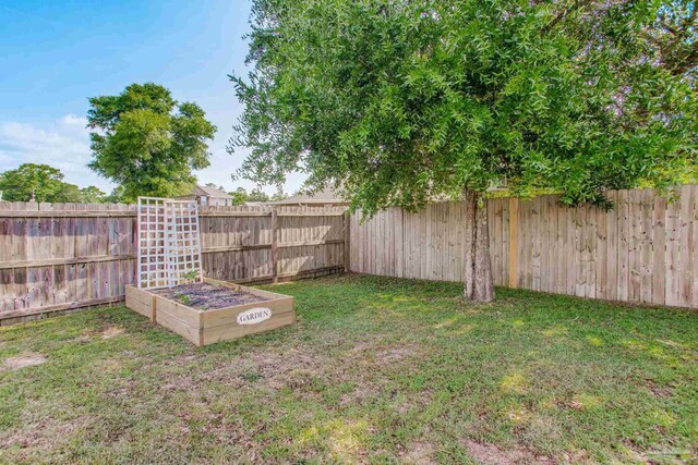 view of yard with a fenced backyard and a vegetable garden