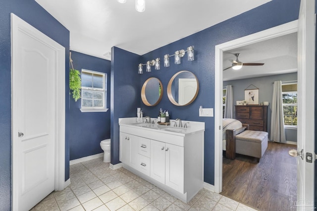 bathroom with ceiling fan, toilet, wood-type flooring, and vanity