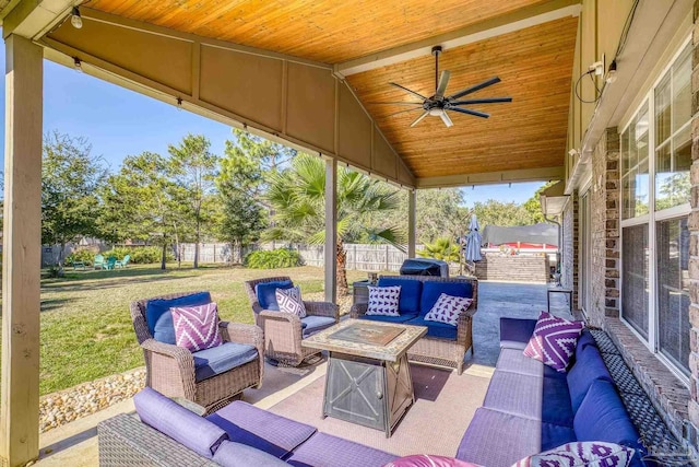 view of patio with ceiling fan and an outdoor living space with a fire pit