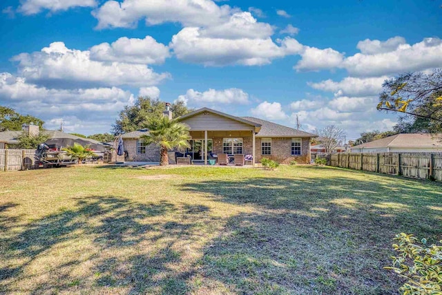 rear view of property featuring a yard and a patio