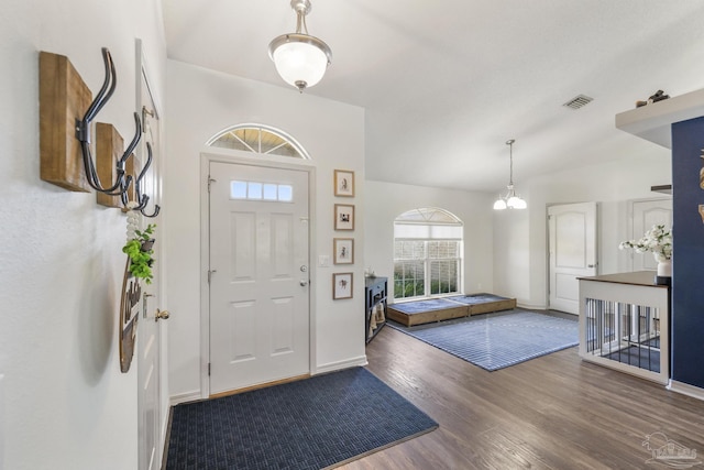 foyer entrance featuring hardwood / wood-style floors and a notable chandelier