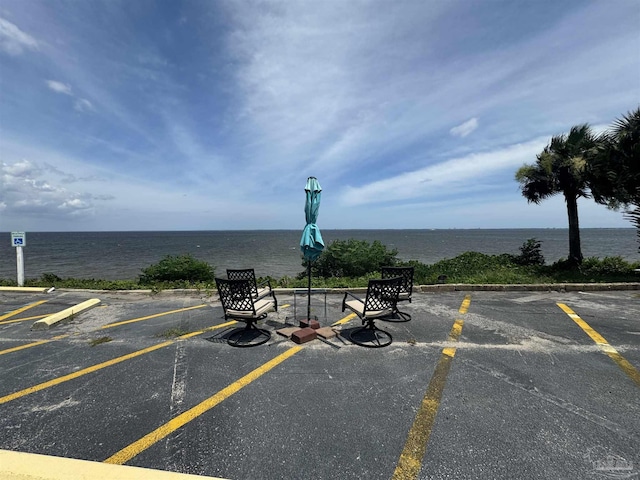 uncovered parking lot featuring a water view