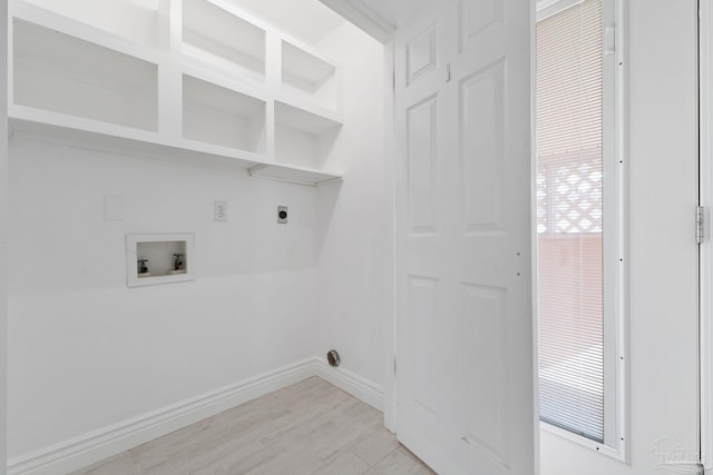 clothes washing area featuring light wood finished floors, baseboards, hookup for a washing machine, plenty of natural light, and electric dryer hookup