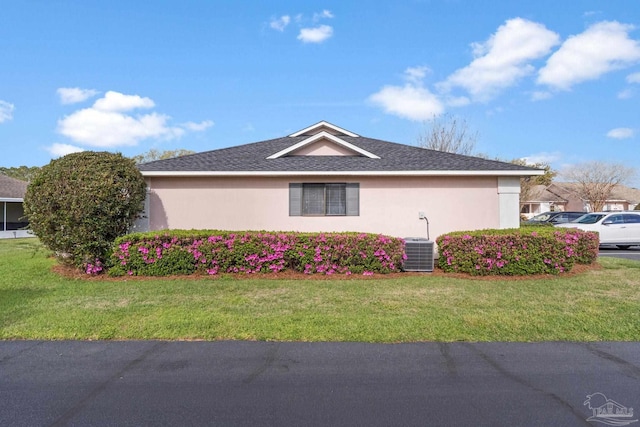 view of property exterior featuring a yard, central AC, and stucco siding