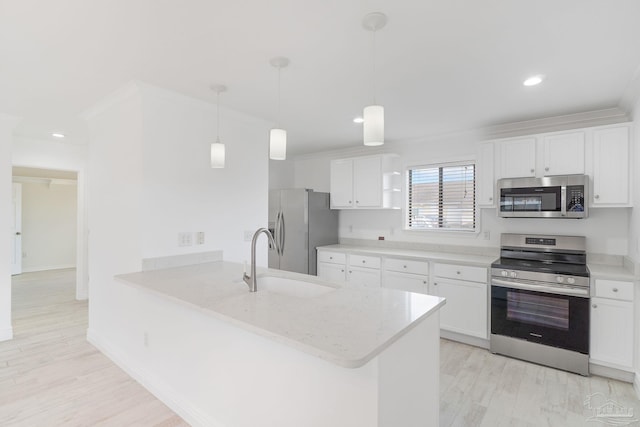 kitchen featuring a sink, stainless steel appliances, a peninsula, white cabinets, and light wood finished floors