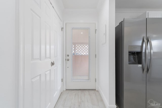 hall featuring baseboards, light wood-style floors, and ornamental molding