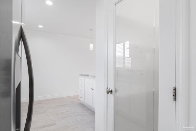 bathroom with recessed lighting, vanity, baseboards, and wood finished floors