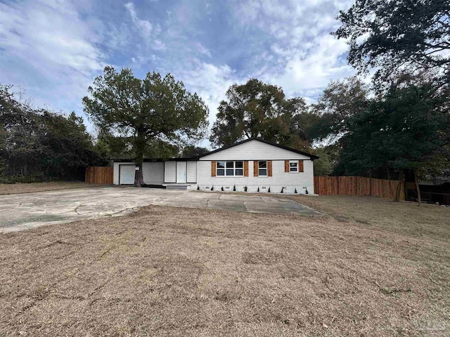 ranch-style house featuring a garage and a front yard