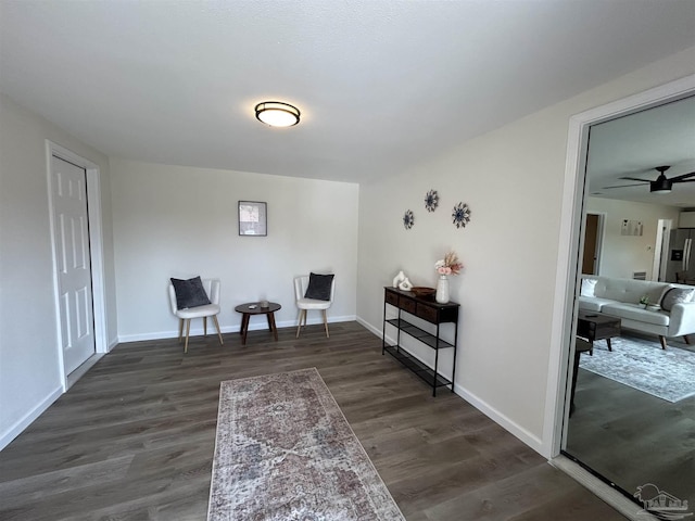 sitting room with ceiling fan and dark hardwood / wood-style flooring