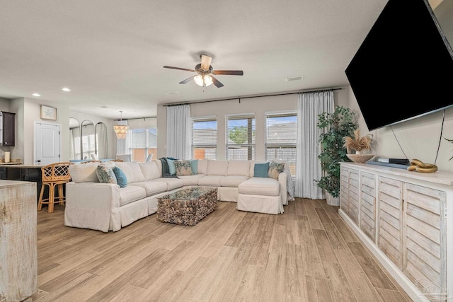 living room with ceiling fan, plenty of natural light, and light wood-type flooring