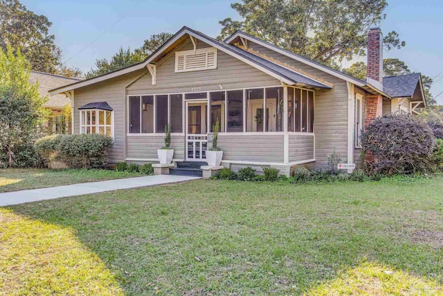 view of front of property featuring a sunroom and a front yard