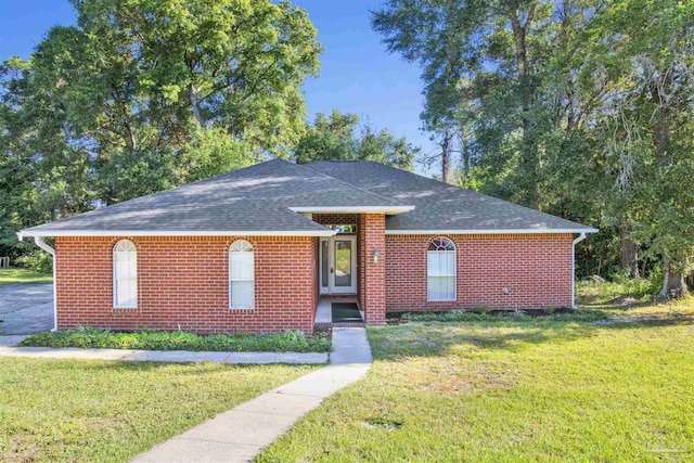 ranch-style home featuring brick siding, a front yard, and a shingled roof