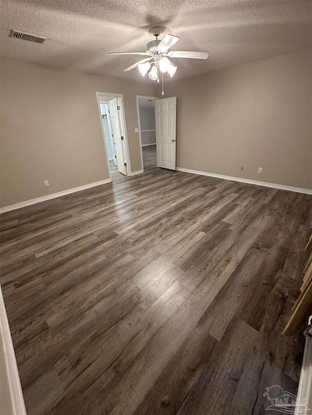 unfurnished bedroom with a textured ceiling, ceiling fan, and dark hardwood / wood-style floors