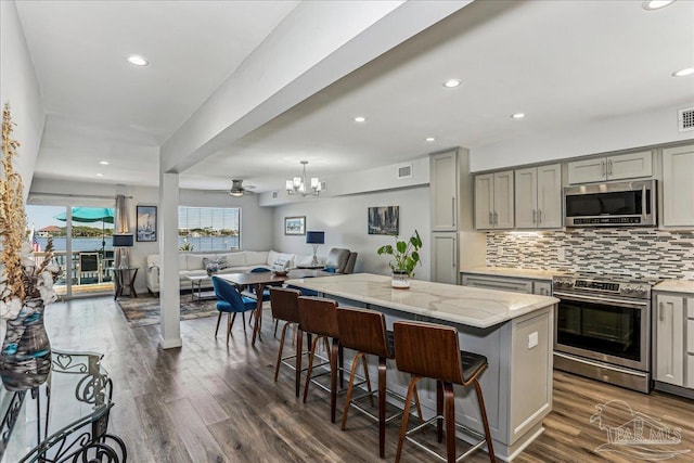 342 Ft Pickens Rd, Pensacola Beach, FL 32561 - kitchen featuring stainless steel appliances, gray cabinetry, open floor plan, decorative backsplash, and dark wood-style floors