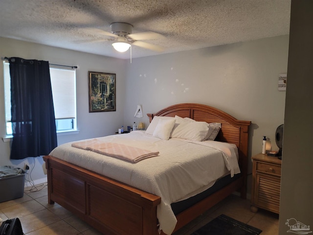 bedroom featuring a ceiling fan, a textured ceiling, and light tile patterned flooring