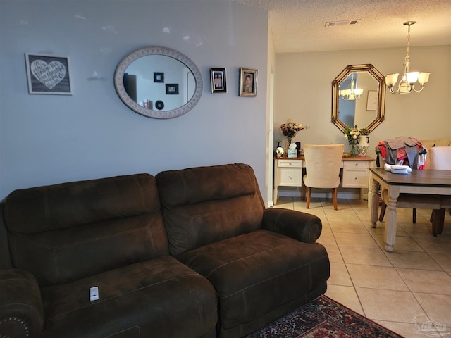 living area featuring light tile patterned floors, visible vents, a chandelier, and a textured ceiling