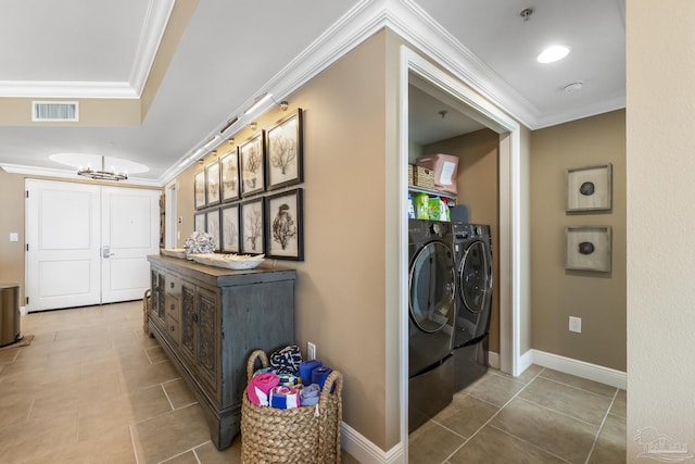 laundry area featuring crown molding, laundry area, baseboards, and washer and dryer