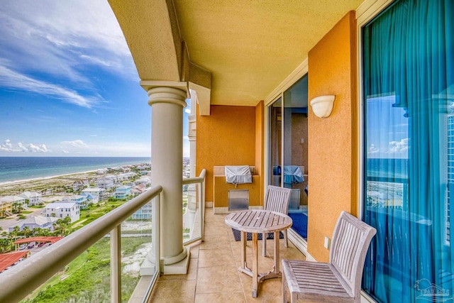 balcony featuring a view of the beach and a water view