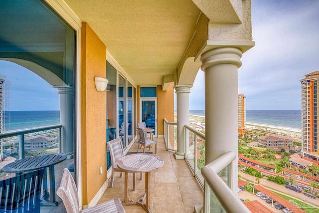 balcony with a water view and a beach view