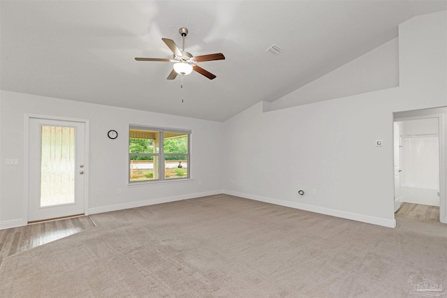 interior space featuring ceiling fan, light colored carpet, and lofted ceiling