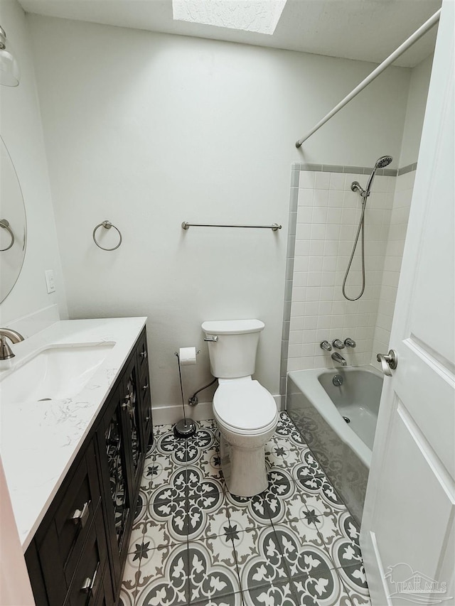 full bathroom with a skylight, tile patterned floors, vanity, toilet, and tiled shower / bath