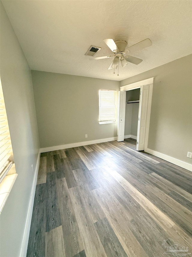 30 Woodham Ave, Ft Walton Beach, FL 32547 - unfurnished bedroom featuring wood finished floors, baseboards, ceiling fan, a closet, and a textured ceiling